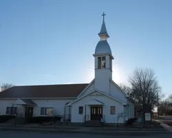 A church with a steeple and a cross on top.