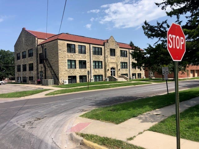 A stop sign on the corner of an intersection.